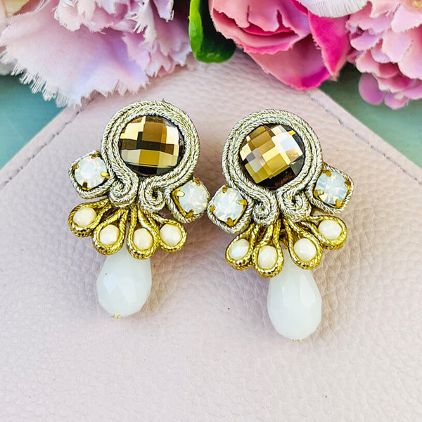 Hübsche kleine Soutache-Ohrringe mit goldfarbenen Bändern und schimmernden Steinen und Tropfe