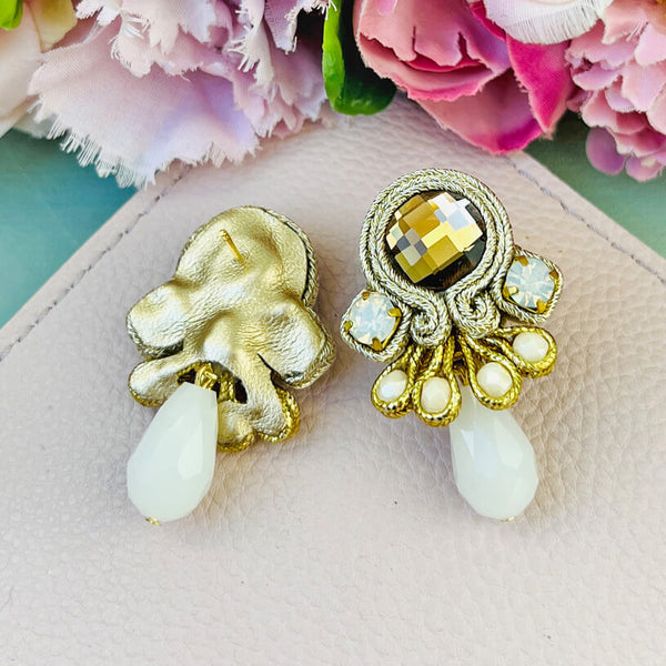 Hübsche kleine Soutache-Ohrringe mit goldfarbenen Bändern und schimmernden Steinen und Tropfe