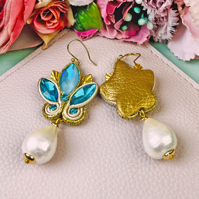 Schöne Soutache-Ohrhänger in Blautönen und Gold mit Baumwolltropfen