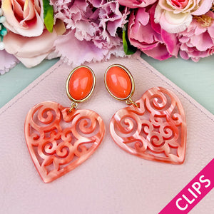 Schöne Ohrclips in schimmerndem Korallorange mit Herz-Ornamenten von AmuseToi