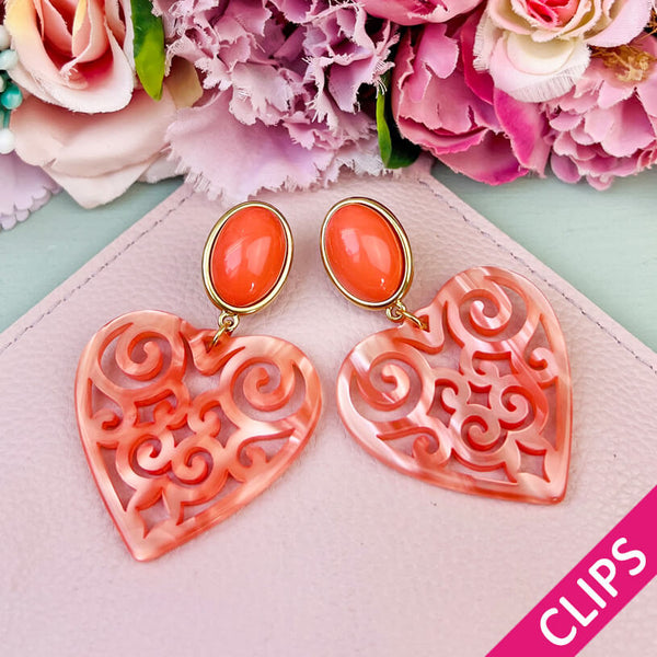 Schöne Ohrclips in schimmerndem Korallorange mit Herz-Ornamenten von AmuseToi