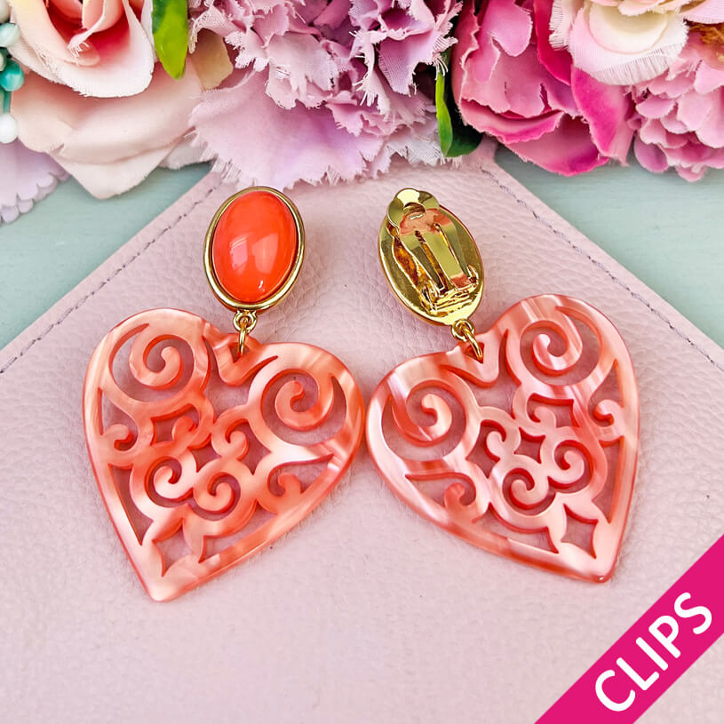 Schöne Ohrclips in schimmerndem Korallorange mit Herz-Ornamenten von AmuseToi