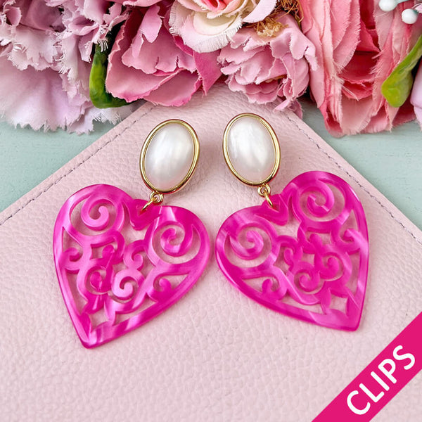 Schöne Herz-Ohrringe mit perlmuttfarbenen Ohrclips und Herz-Ornamenten in Pink