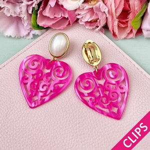 Schöne Herz-Ohrringe mit perlmuttfarbenen Ohrclips und Herz-Ornamenten in Pink