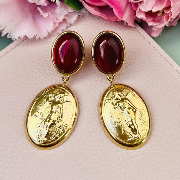 Dunkelrote Ohrstecker mit Putte auf goldenem Oval