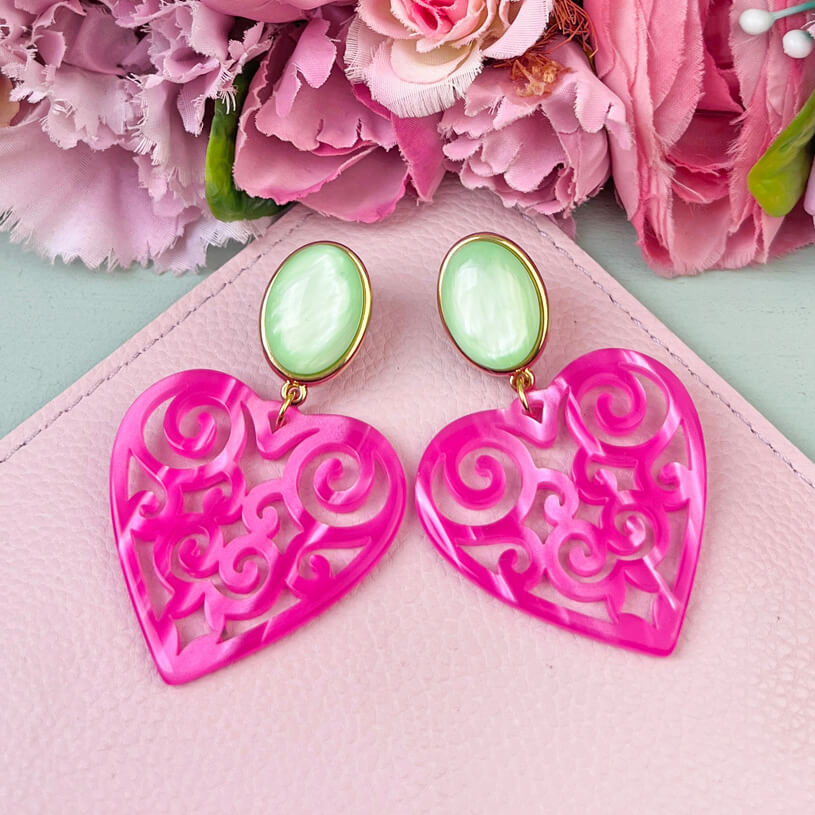 Schöne Herz-Ohrringe mit hellgrünem Ohrsteckern und Herz-Ornamenten in Pink
