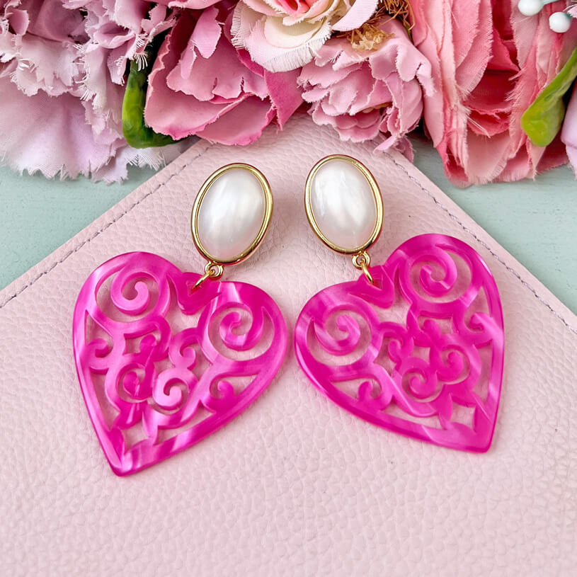 Schöne Herz-Ohrringe mit perlmuttfarbenen Ohrsteckern und Herz-Ornamenten in Pink