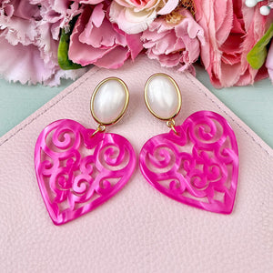 Schöne Herz-Ohrringe mit perlmuttfarbenen Ohrsteckern und Herz-Ornamenten in Pink