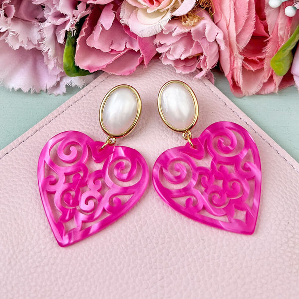 Schöne Herz-Ohrringe mit perlmuttfarbenen Ohrsteckern und Herz-Ornamenten in Pink