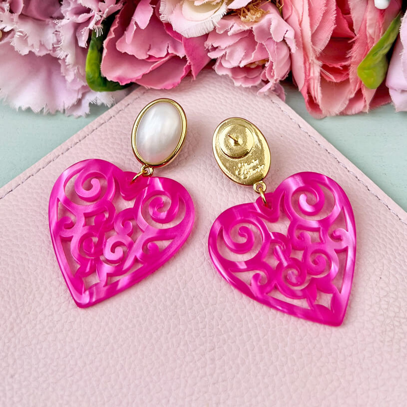 Schöne Herz-Ohrringe mit perlmuttfarbenen Ohrsteckern und Herz-Ornamenten in Pink