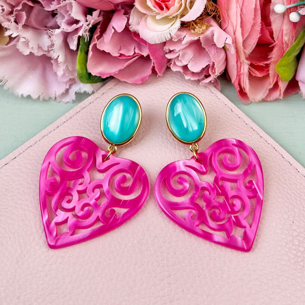 Schöne Herz-Ohrringe mit türkisfarbenen Ohrsteckern und Herz-Ornamenten in Pink