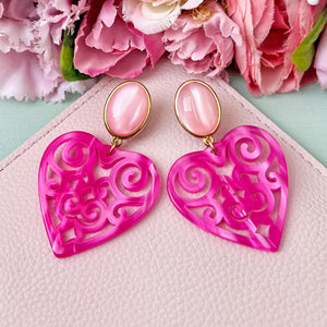 Schöne Herz-Ohrringe mit rosafarbenen Ohrsteckern und Herz-Ornamenten in Pink