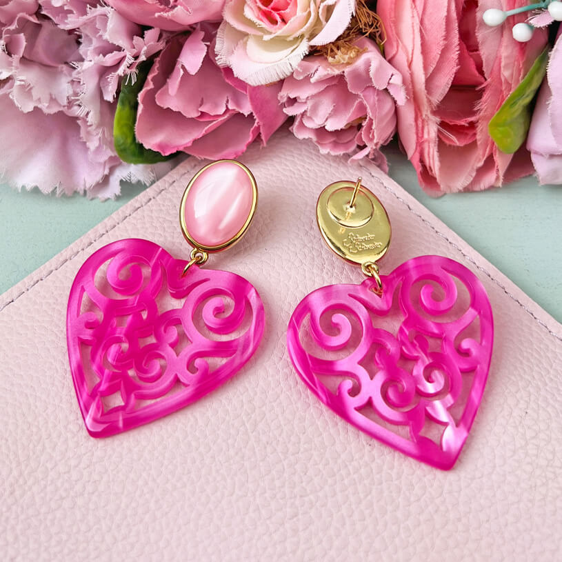 Schöne Herz-Ohrringe mit rosafarbenen Ohrsteckern und Herz-Ornamenten in Pink
