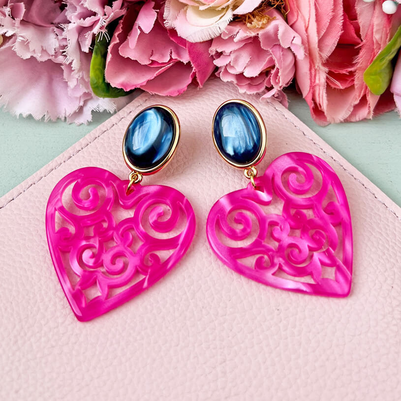 Schöne Herz-Ohrringe mit dunkelblauen Ohrsteckern und Herz-Ornamenten in Pink