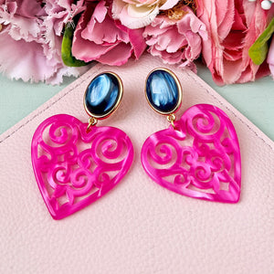 Schöne Herz-Ohrringe mit dunkelblauen Ohrsteckern und Herz-Ornamenten in Pink