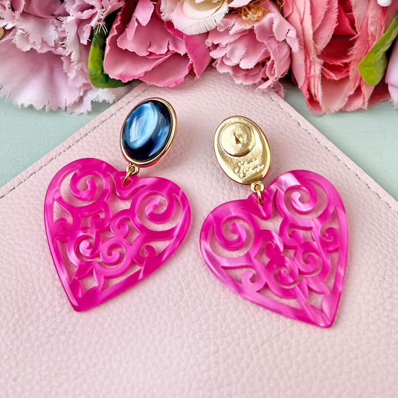 Schöne Herz-Ohrringe mit dunkelblauen Ohrsteckern und Herz-Ornamenten in Pink