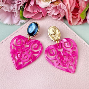 Schöne Herz-Ohrringe mit dunkelblauen Ohrsteckern und Herz-Ornamenten in Pink