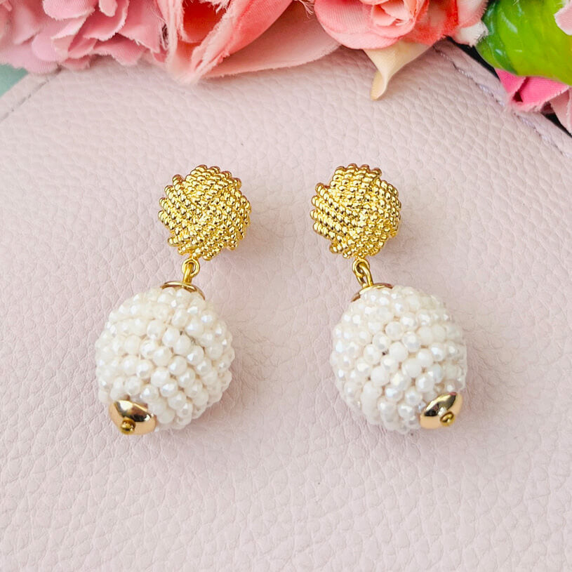 Vergoldete Knoten-Ohrringe mit funkelnden Kugeln in Creme