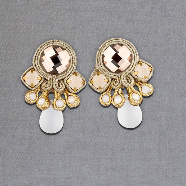 Hübsche kleine Soutache-Ohrringe mit goldfarbenen Bändern und schimmernden Steinen und Tropfe