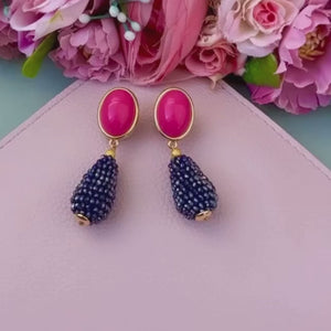 Pinkfarbene Ohrstecker mit glitzerndem dunkelblauen Tropfen von AmuseToi
