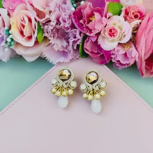 Hübsche kleine Soutache-Ohrringe mit goldfarbenen Bändern und schimmernden Steinen und Tropfe